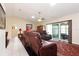 Bright living room with vaulted ceilings and a sliding glass door, showcasing comfortable seating and dark wood flooring at 4723 Saint Andrews Arc, Leesburg, FL 34748