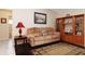 Relaxing living room featuring a plush sofa, dark wood flooring, and a built-in bookcase with display shelves at 4723 Saint Andrews Arc, Leesburg, FL 34748