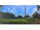 Community tennis court surrounded by lush landscaping and a clear blue sky at 4723 Saint Andrews Arc, Leesburg, FL 34748