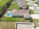 Aerial view of a home with a pool, green lawn, and solar panels, nestled in a well-maintained neighborhood at 485 Halter Dr, Apopka, FL 32712