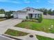 Landscaped single-story home with a three-car garage, spacious driveway, and well-kept lawn at 485 Halter Dr, Apopka, FL 32712