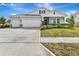 Single-story home with a three-car garage, neat landscaping, and a charming front porch at 485 Halter Dr, Apopka, FL 32712