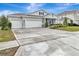 Home featuring a three-car garage and a long driveway; lawn is green and well maintained at 485 Halter Dr, Apopka, FL 32712