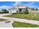 Well-manicured lawn and landscaping surround this home with a three-car garage at 485 Halter Dr, Apopka, FL 32712
