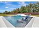 Sparkling pool with built-in spa and lounge chairs, set against a backdrop of lush greenery and blue skies at 485 Halter Dr, Apopka, FL 32712