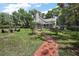 Brick path leads to the house with lush landscaping, firepit, and patio seating creating a private backyard at 4920 Sw 4Th Cir, Ocala, FL 34471