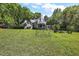 Expansive backyard featuring lush lawn, fire pit, mature trees, and an outdoor recreation area at 4920 Sw 4Th Cir, Ocala, FL 34471