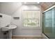 A bright bathroom featuring a stylish pedestal sink, a shower with glass door, and natural light at 4920 Sw 4Th Cir, Ocala, FL 34471