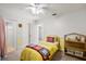 room with yellow and white paneled walls, a simple bed, and a convenient storage shelf at 4920 Sw 4Th Cir, Ocala, FL 34471