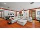 Spacious living room with hardwood floors, large sectional sofa, and plenty of natural light at 4920 Sw 4Th Cir, Ocala, FL 34471
