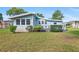 Quaint light blue home with a cozy patio and well-maintained lawn in a serene setting at 501 Santa Fe Rd, Tavares, FL 32778
