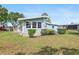 Light blue house with a manicured lawn and charming landscaping at 501 Santa Fe Rd, Tavares, FL 32778