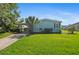 Charming single-story home featuring a lush green lawn, carport, and mature palm tree at 501 Santa Fe Rd, Tavares, FL 32778