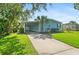 Charming light blue home with a well-manicured lawn, covered parking, and a palm tree in the front yard at 501 Santa Fe Rd, Tavares, FL 32778