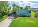 Charming blue home with lush landscaping, carport and well maintained lawn at 501 Santa Fe Rd, Tavares, FL 32778