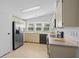 Bright kitchen with stainless steel refrigerator, neutral cabinets, and a bay window above the sink at 501 Santa Fe Rd, Tavares, FL 32778