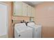 Efficient laundry room featuring a washer, dryer, and overhead storage cabinets at 501 Santa Fe Rd, Tavares, FL 32778