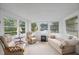 Comfortable sunroom featuring large windows with views of a pond, and neutral furniture at 501 Santa Fe Rd, Tavares, FL 32778