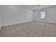 Large upstairs bedroom features neutral carpet and a large window overlooking the yard at 5173 Waypointe Blvd, Apopka, FL 32712