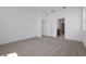 Spacious bedroom featuring carpeted floors and a view of the ensuite bathroom and walk-in closet at 5173 Waypointe Blvd, Apopka, FL 32712