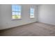 A bright bedroom featuring plush carpeting and two large windows at 5173 Waypointe Blvd, Apopka, FL 32712