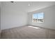 Well-lit bedroom with a large window offering natural light and scenic views, carpeted floors, and white walls at 5173 Waypointe Blvd, Apopka, FL 32712