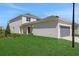 View of the home with a side entry two-car garage and lush green lawn at 5173 Waypointe Blvd, Apopka, FL 32712