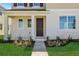 Inviting front entrance with a dark brown door, manicured lawn, and decorative landscaping at 5173 Waypointe Blvd, Apopka, FL 32712