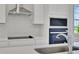 Close-up of the kitchen featuring stainless steel hood, electric stove top and built-in microwave and oven at 5173 Waypointe Blvd, Apopka, FL 32712