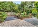 View of fenced-in backyard patio area featuring mature landscaping and gravel beds at 545 W Cummings St, Lake Alfred, FL 33850