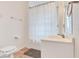 Bathroom with white vanity, tile floor, and bathtub shower with white shower curtain at 545 W Cummings St, Lake Alfred, FL 33850