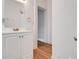 Bathroom with white vanity and hardwood floors leading to doorway at 545 W Cummings St, Lake Alfred, FL 33850