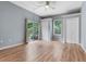 Spacious bedroom featuring wood-look floors, closet, ceiling fan and large sliding glass door at 545 W Cummings St, Lake Alfred, FL 33850