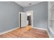 Bright bedroom with wood-look flooring, open door to kitchen with stainless steel appliances at 545 W Cummings St, Lake Alfred, FL 33850