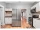 Kitchen featuring stainless steel appliances, white cabinets, granite countertops, and hardwood floors at 545 W Cummings St, Lake Alfred, FL 33850