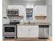 Kitchen with stainless steel appliances, granite countertops, white cabinets, and tiled backsplash at 545 W Cummings St, Lake Alfred, FL 33850
