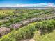 Beautiful aerial view of residences nestled among trees with a golf course nearby, under a partly cloudy sky at 602 Camino Real Blvd # 602, Howey In The Hills, FL 34737