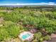 An aerial shot showcases a pool area amidst lush trees and a scenic view of the horizon at 602 Camino Real Blvd # 602, Howey In The Hills, FL 34737