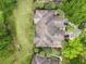 Aerial view of a tile roof, showcasing palm trees, cars in driveway, and manicured green grass at 602 Camino Real Blvd # 602, Howey In The Hills, FL 34737