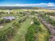 An aerial view showcasing a golf course, pond, and nearby homes at 602 Camino Real Blvd # 602, Howey In The Hills, FL 34737