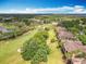 Aerial view showcases luxurious community with golf course, clubhouse, and meticulously landscaped grounds at 602 Camino Real Blvd # 602, Howey In The Hills, FL 34737