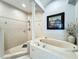 Luxurious bathroom featuring a soaking tub, walk-in shower, and decorative column creating a spa-like experience at 602 Camino Real Blvd # 602, Howey In The Hills, FL 34737