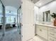 Bright bathroom with a vanity and an arched doorway leading to the bedroom with mirrored closet doors at 602 Camino Real Blvd # 602, Howey In The Hills, FL 34737