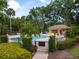 Community pool area surrounded by lush landscaping, a pool house, and ample seating for relaxation at 602 Camino Real Blvd # 602, Howey In The Hills, FL 34737