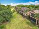 Aerial view of upscale condominiums featuring lush green lawns, mature trees, and tile roofs at 602 Camino Real Blvd # 602, Howey In The Hills, FL 34737
