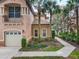 Charming exterior view featuring an attached garage, lush landscaping and tile roof at 602 Camino Real Blvd # 602, Howey In The Hills, FL 34737