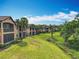 Stunning row of Mediterranean-style homes with lush green lawns and mature palm trees at 602 Camino Real Blvd # 602, Howey In The Hills, FL 34737