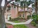 Charming two-story townhouse featuring a stucco facade, tile roof, balcony, and mature palm trees enhancing curb appeal at 602 Camino Real Blvd # 602, Howey In The Hills, FL 34737