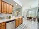Efficient kitchen layout with wood cabinets, and stainless dishwasher overlooking the dining area at 602 Camino Real Blvd # 602, Howey In The Hills, FL 34737