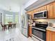 Well-lit kitchen with stainless steel appliances and wood cabinets next to the dining room at 602 Camino Real Blvd # 602, Howey In The Hills, FL 34737